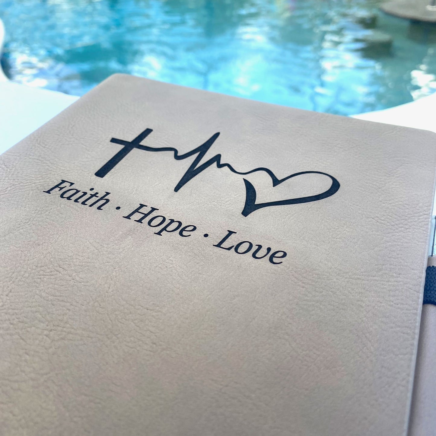 Close up of the Iron Gray colored journal engraved with Faith Hope Love.