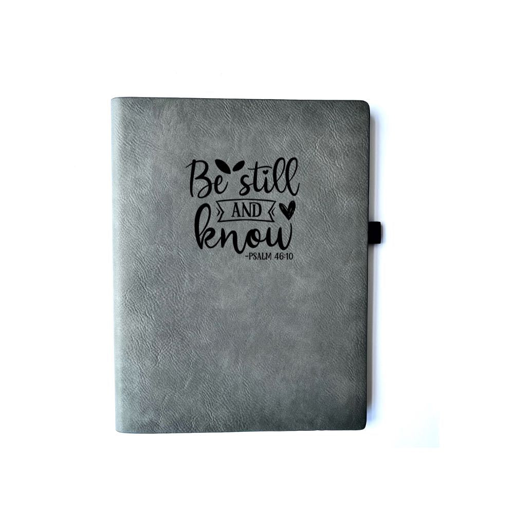 Iron Gray Faux leather journal with "BE STILL AND KNOW PSALM 46:10" engraved on it. Can be personalized with your name or business logo in the bottom right corner. The Iron Gray journal does not come with a matching pen.