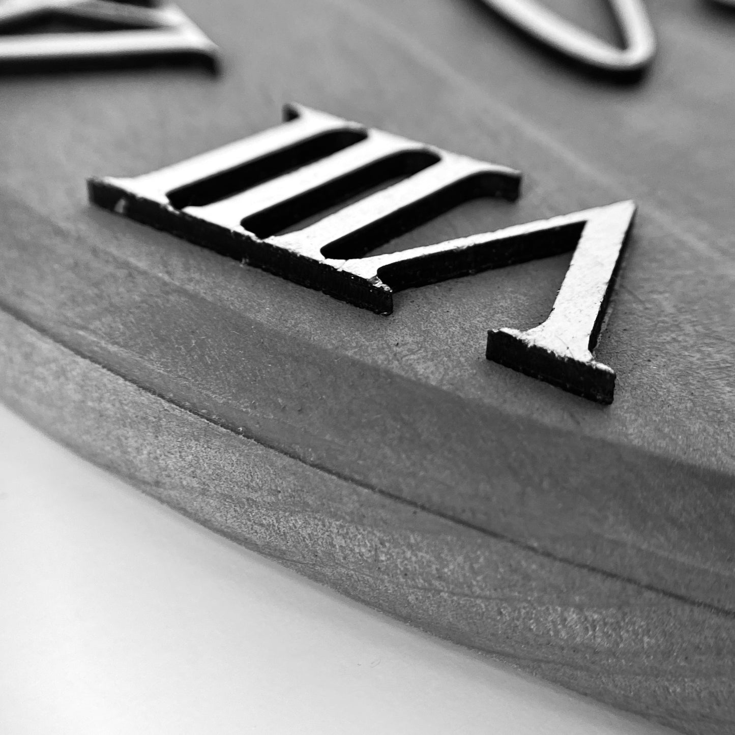 Side view of Classic Grey clock to show thickness of the wood and bevelled edge.  View of roman numerals.